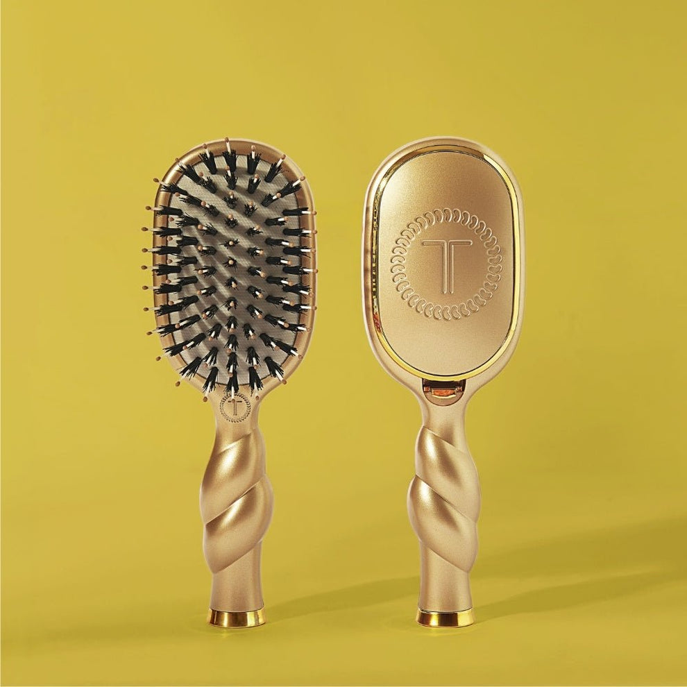 Two TELETIES Golden Glow mini boar bristle hair brushes showing bristles and gold T logo back on a yellow backdrop
