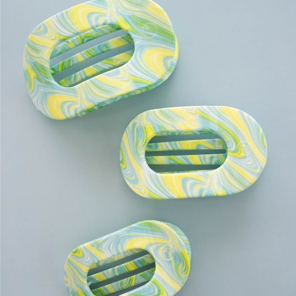 TELETIES By the Sea Shore small flat round hair clip in green, yellow, and white swirled pattern. Bendable teeth for secure hold.
