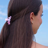 TELETIES Classic Pinch Me! Tiny Claw Clip in pink marble pattern, holding back dark brown hair.
