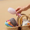 TELETIES Pinch Me! Detangler Hair Brush Bundle with pink tie-dye swirl pattern, beach setting
