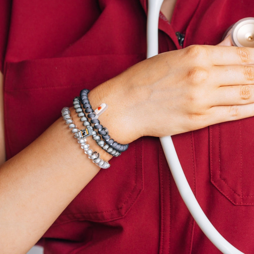 TELETIES Good Hair Rx small spiral hair ties in grey and silver worn as a bracelet by a healthcare worker
