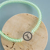 TELETIES By the Sea Shore green spiral headband with no-slip rubber stopper and T logo.

