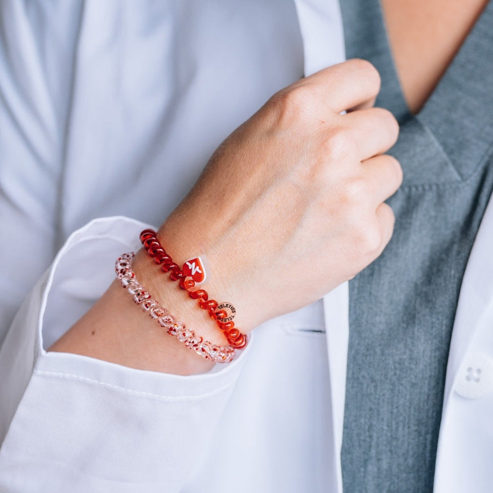 TELETIES Heart and Hustle small hair ties worn as bracelets on a healthcare professional in a white lab coat
