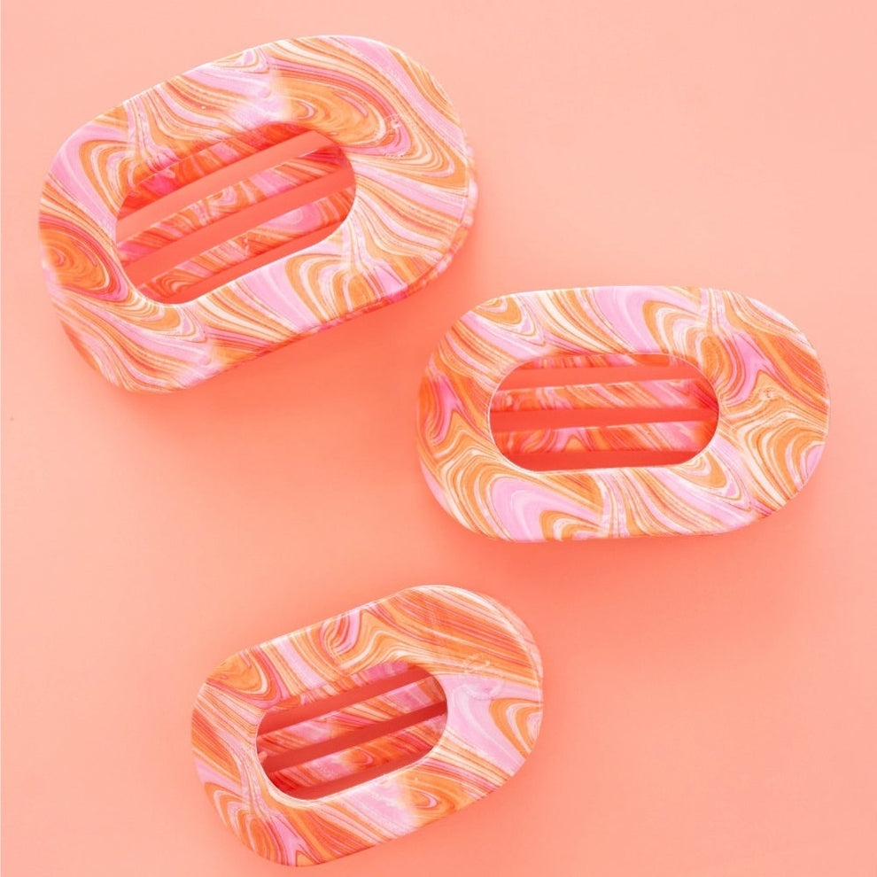 TELETIES Just Keep Swimming large flat round hair clip in pink and orange marble pattern. Bendable teeth for secure hold.
