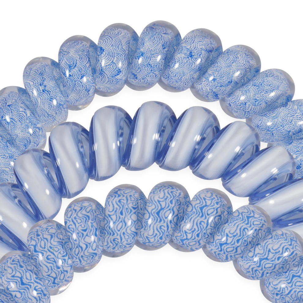 TELETIES large blue spiral hair ties with white wave pattern and solid blue ties. Gentle, waterproof, and doubles as a bracelet.
