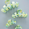 TELETIES By the Sea Shore Large Claw Clip in green with a marbled swirl pattern of yellow and blue. size comparison
