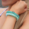 TELETIES By the Sea Shore large hair ties in teal and green spiral design, worn on wrist as bracelet.
