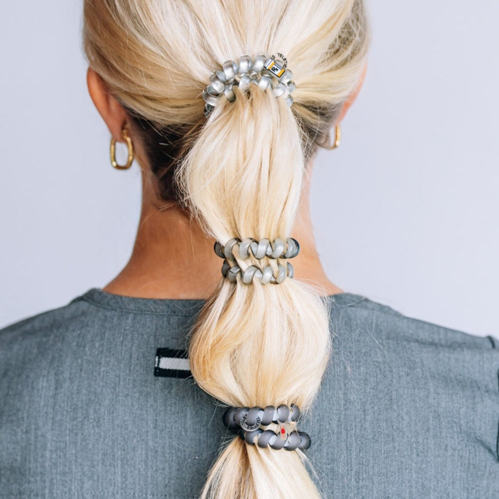 TELETIES Good Hair Rx large spiral hair ties in grey worn in a blonde ponytail by a healthcare professional
