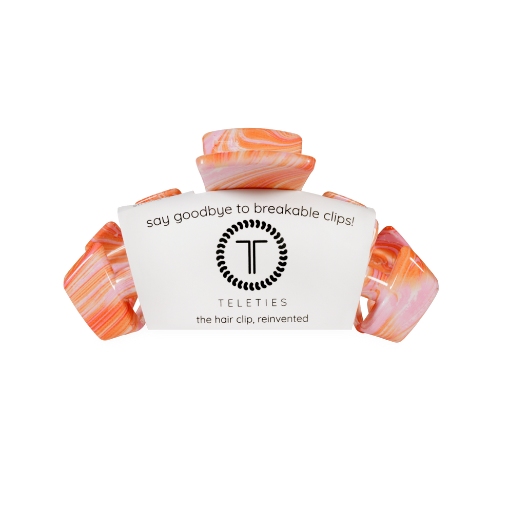 TELETIES medium claw clip in pink and orange marbled pattern. Designed for a secure hold, suitable for all hair types.

