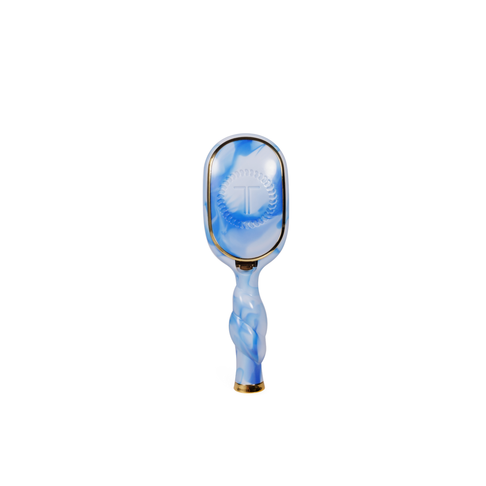 TELETIES mini detangler hair brush with blue and white tie-dye swirl pattern, gold trim, and built-in mirror.
