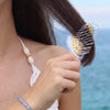 TELETIES Mini Vented Hair Brush with anti-static bristles and gold pins, perfect for travel and quick styling.
