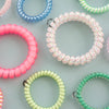 TELETIES Pinch Me! Bundle of colorful spiral hair ties and clips in pink, blue, green, and white with red and blue speckles.
