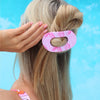 TELETIES Pinch Me! Bundle oval hair clip in pink marble pattern holding blonde hair in a bun.
