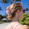 TELETIES Classic Pinch Me! Medium Claw Clip in pink marble pattern, holding a blonde woman's hair in a bun.
