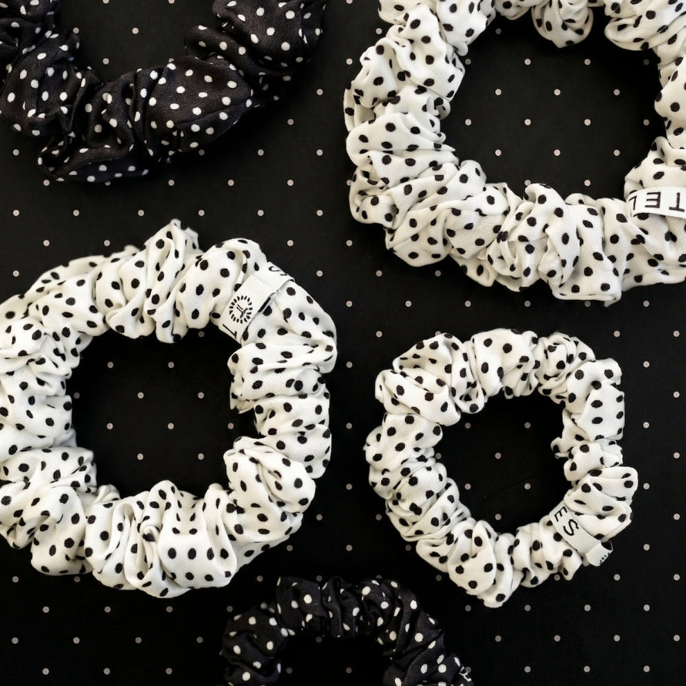 TELETIES large silk scrunchies in black and white polka dot print, featuring a gentle grip coil for hair protection.
