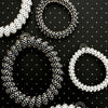 TELETIES large spiral hair ties in a black and white polka dot pattern, designed for a strong, crease-free hold.
