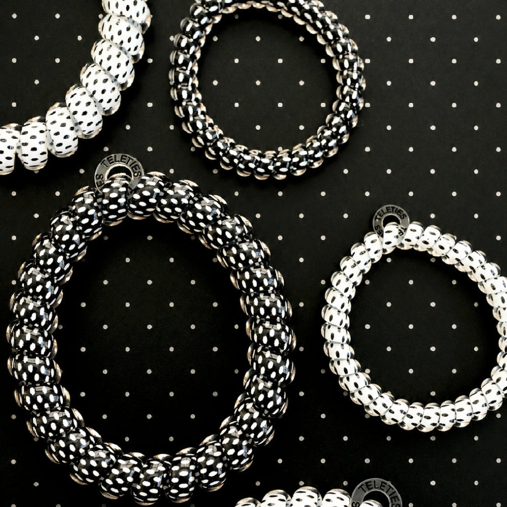 TELETIES large spiral hair ties in a black and white polka dot pattern, designed for a strong, crease-free hold.
