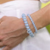 TELETIES blue and white swirled small hair ties worn as bracelets on a wrist. Gentle on hair.
