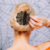 TELETIES black spider web flat hair clip worn in a blonde bun for a comfortable and secure hold
