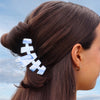 TELETIES Tide & True Bundle hair clips in white and blue marble pattern, styled in brown hair.
