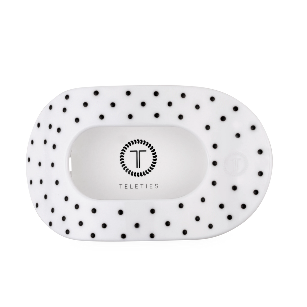 TELETIES large flat round hair clip in white with black polka dots, designed for comfortable wear against headrests.
