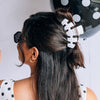 TELETIES large white hair claw clip with black polka dots styled in a half-up hairstyle
